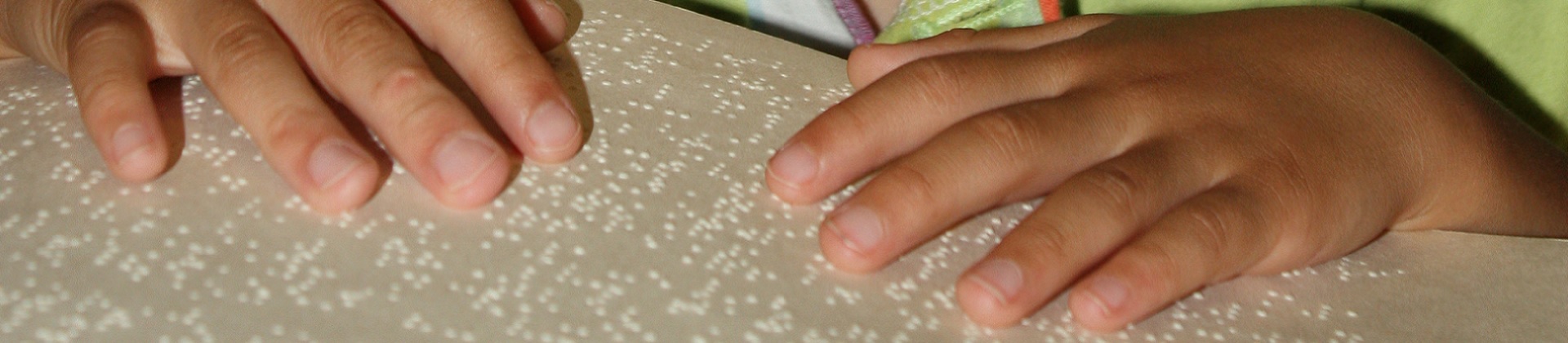  A child's hands on a Braille book.