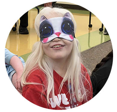 A young girl smiles with her cat eye learning shades on