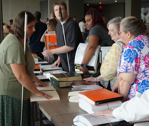 Blind adults explore the selection of Braille books available at the annual Braille Book Fair