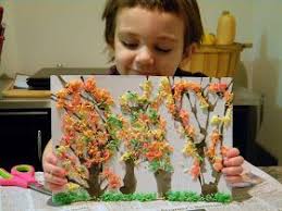 A young girl proudly holds up her tactile art.